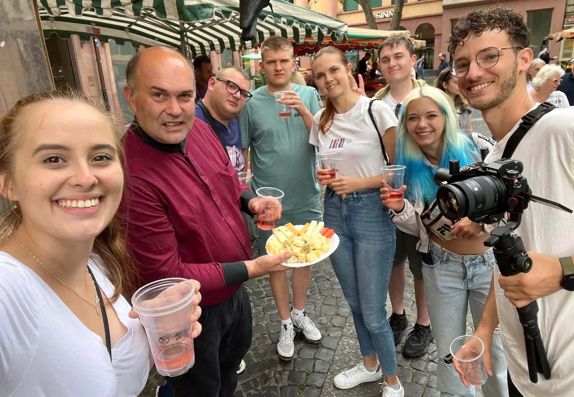 Teilnehmer eines Online-Kochkurses von LebeMensch erleben gemeinsam Genuss und Kulinarik auf einem regionalen Markt