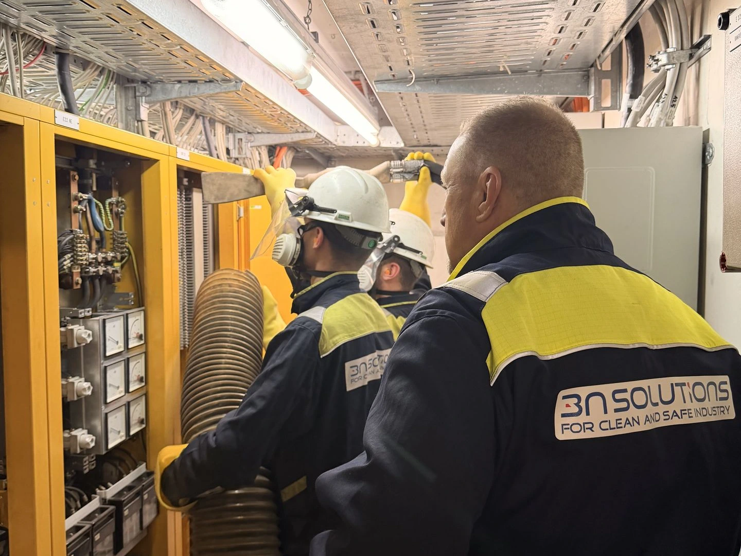 Techniker bei der Reinigung elektrischer Anlagen in einer industriellen Schaltanlage