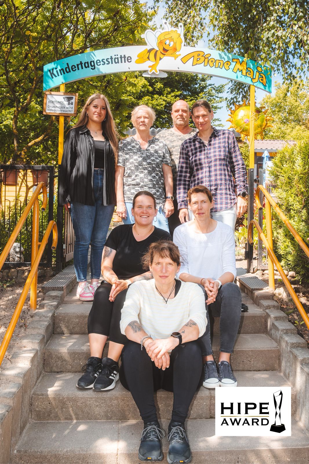 Das Team der Kindertagesstätte Biene Maja vor der Einrichtung – private Kita in Stralsund und HIPE AWARD Preisträgerin.