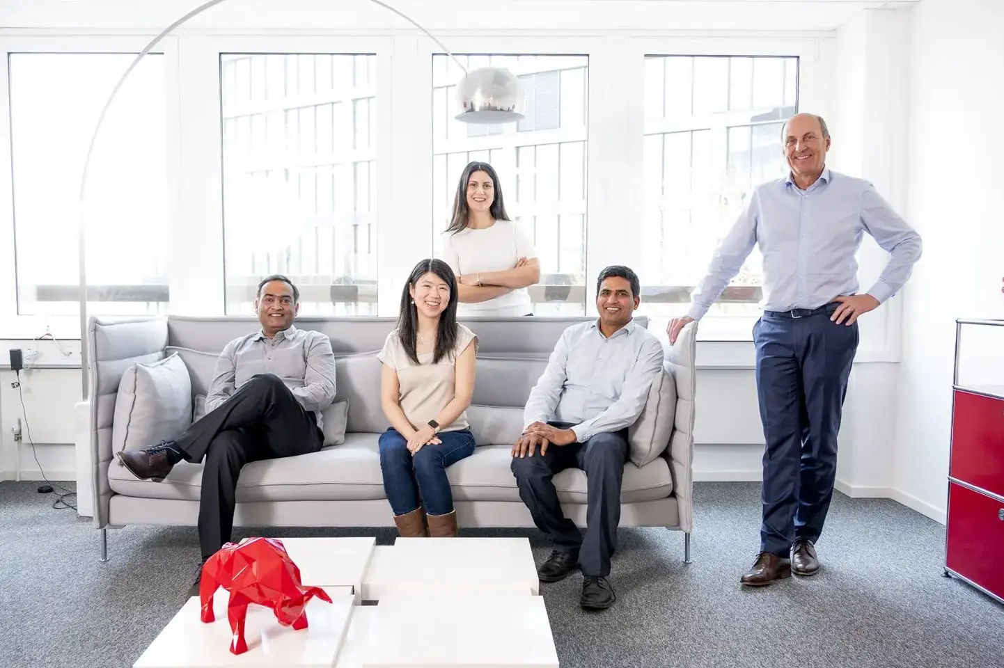 Internationales Team von Confinity Solutions im Büro in Eschborn – fünf Mitarbeitende entspannt in moderner Arbeitsumgebung.